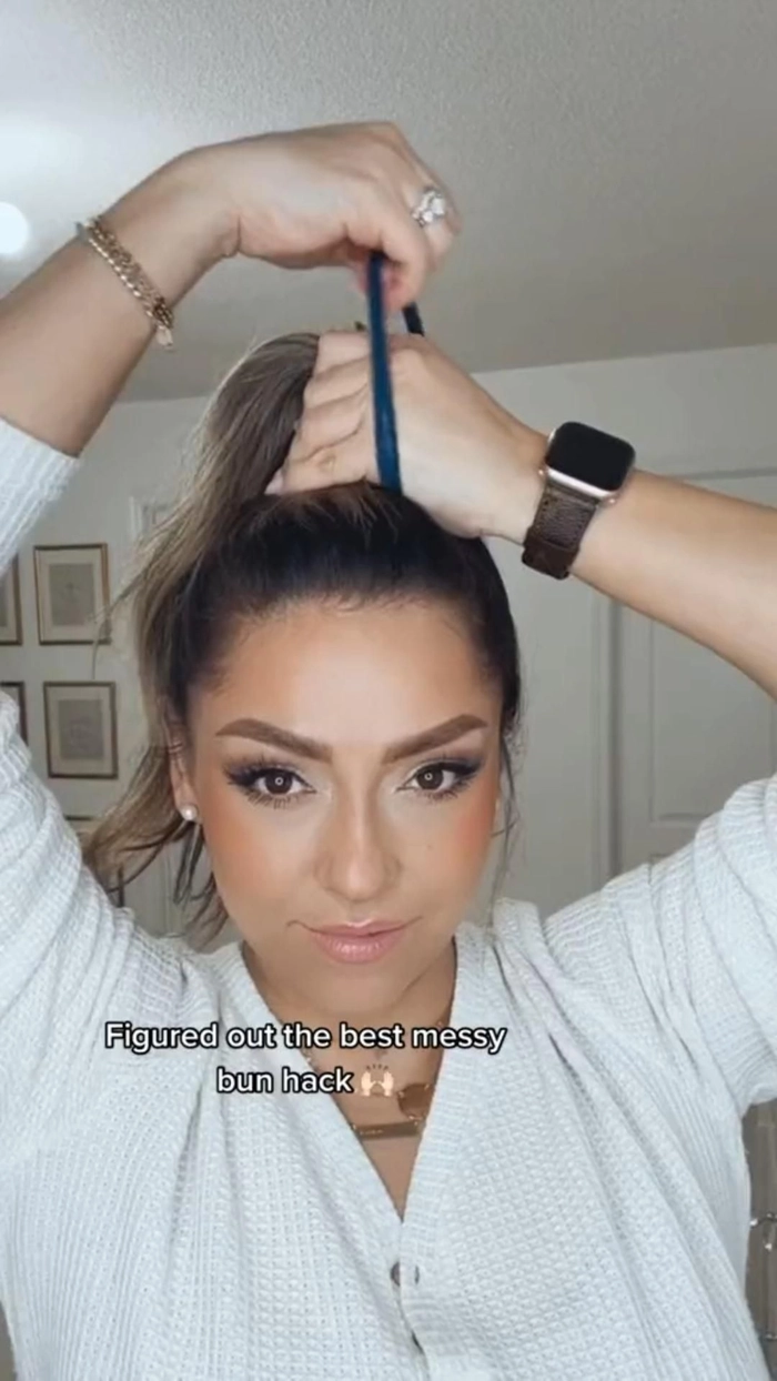 Woman with a casual messy beach bun hairstyle, wind-tousled texture