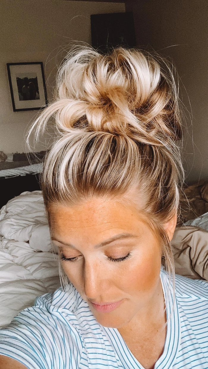 Effortless messy beach bun with loose strands for a relaxed summer vibe