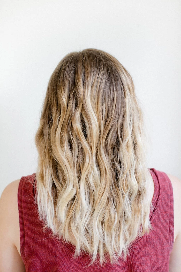 Woman with soft overnight beach wave hairstyle resting on a silk pillowcase