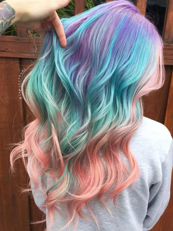 Woman with pastel blue hair styled in beach waves at the shoreline