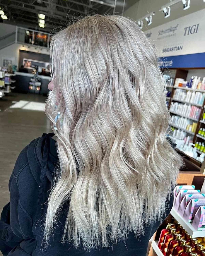 Platinum blonde beach waves with sandy texture and soft sea spray