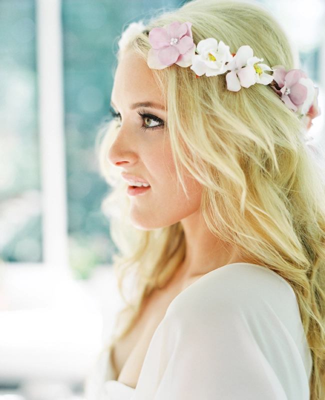 Romantic beach hairstyle with soft waves and delicate flowers woven through