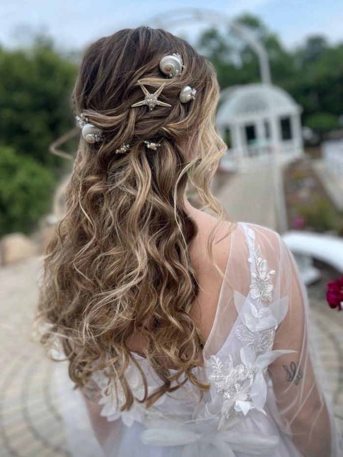 Bride wearing a delicate seashell hair comb for a beach wedding ceremony, wind-tousled waves and soft sunlit glow