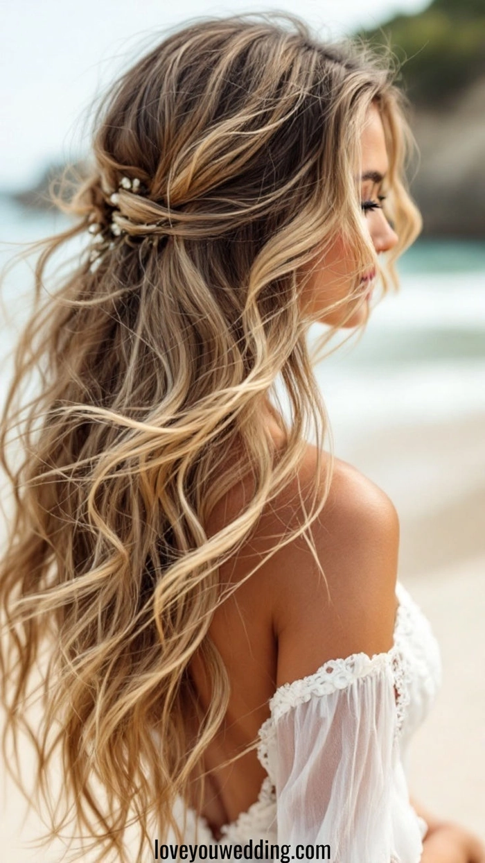 Short beach wedding hair styled with soft waves and floral accents
