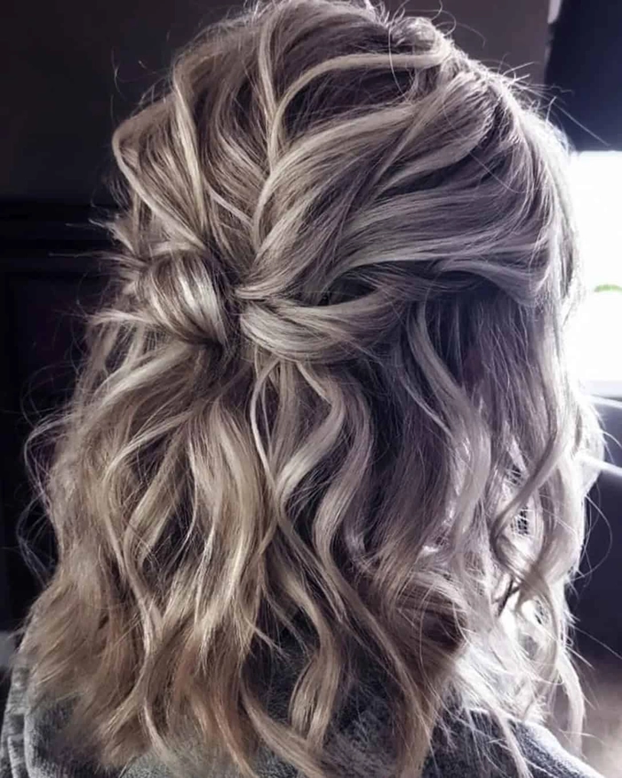 Short beach wedding hairstyle with soft waves and floral accents