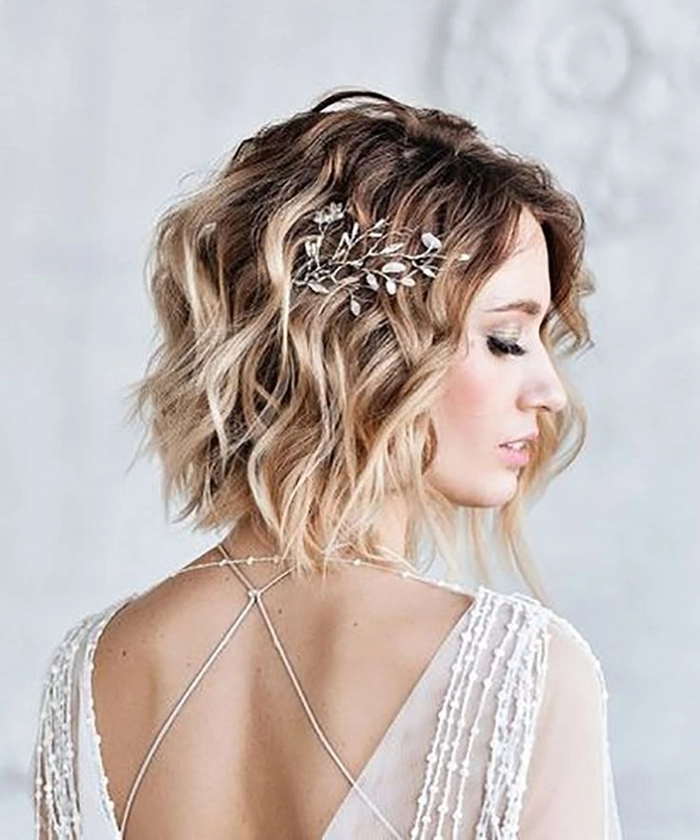 Short beach wedding hairstyle with soft waves and floral accessories