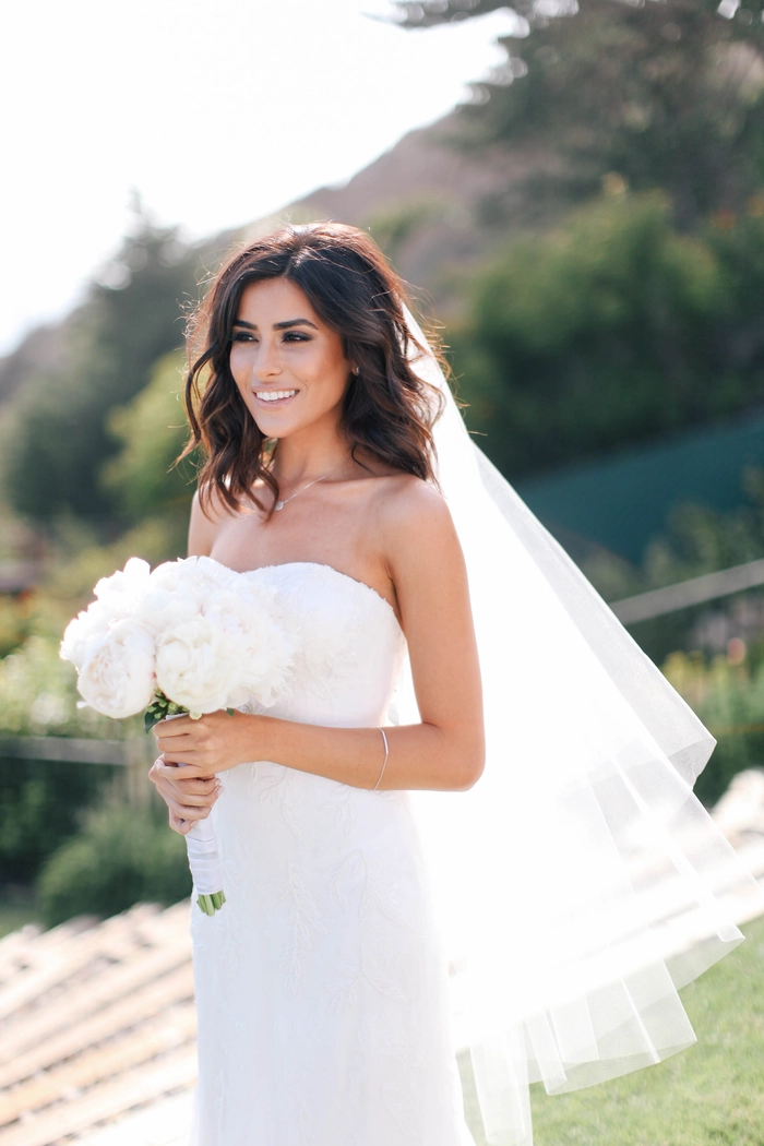 Short beach wedding hairstyle with soft waves and delicate floral accents