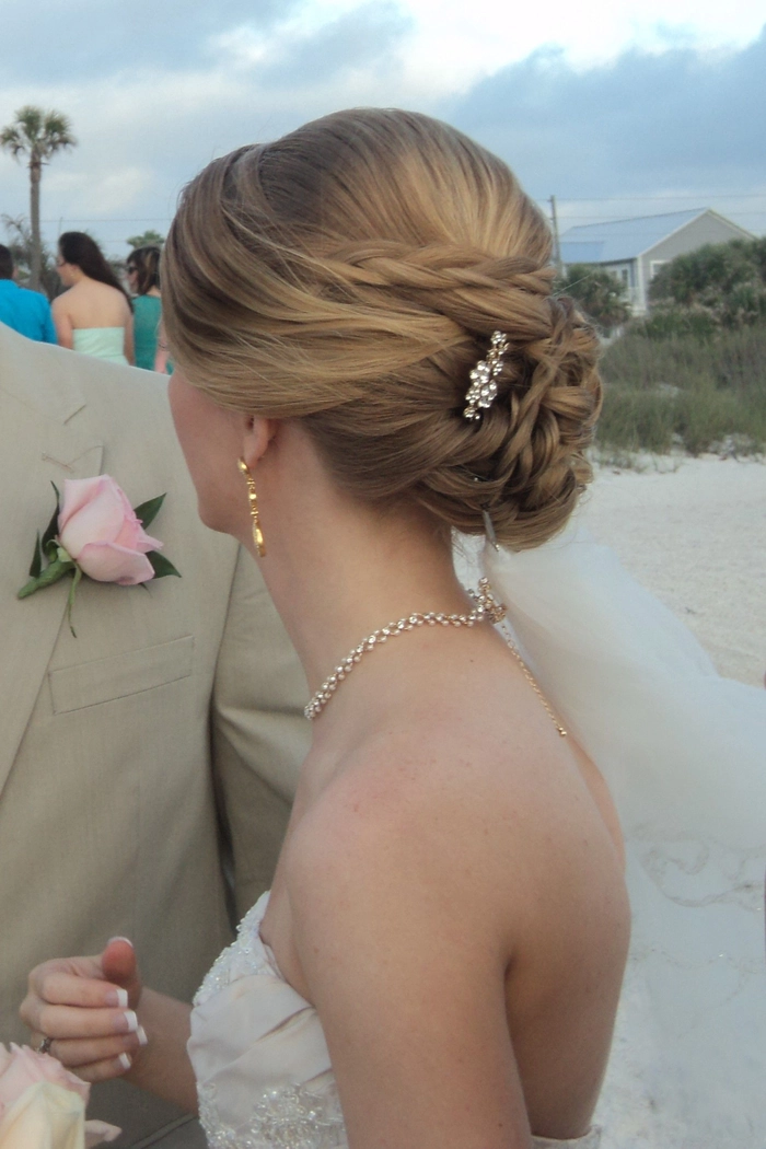 Short bride with tousled beach waves and delicate flowers in her hair