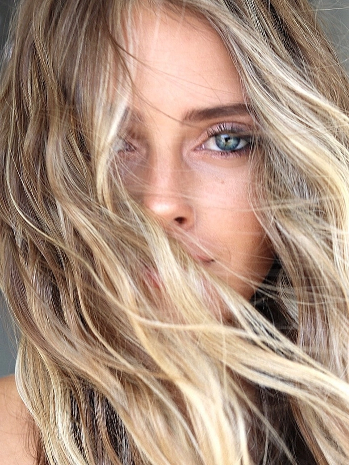Sun kissed highlights beach looks on long blonde wavy hair with beachy texture