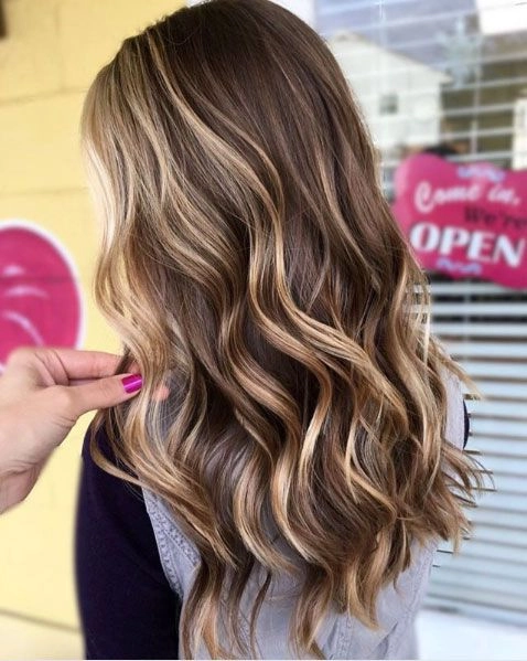 Sun kissed highlights on beach waves for a carefree summer hairstyle