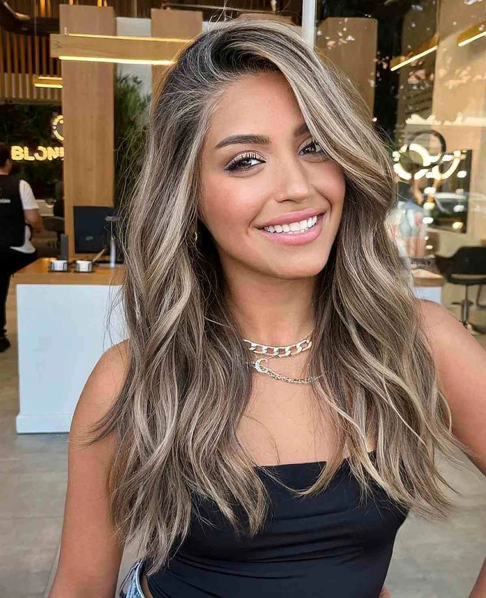 Women with sun-kissed blonde highlights and beachy waves walking along the shoreline