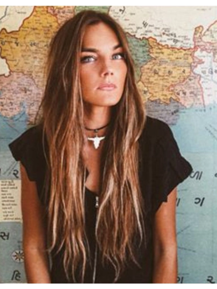 Beautiful surfer girl with beachy waves and tousled hair against a sunny ocean backdrop