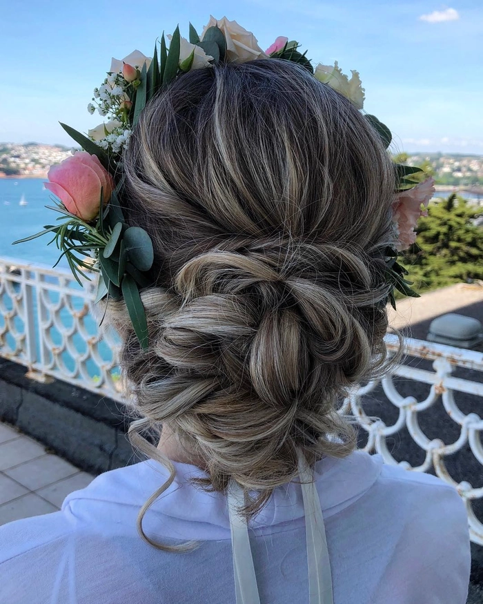 Thick hair styled in a beach updo with a tousled bun and soft tendrils