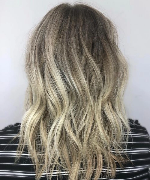 Woman with thin hair using braiding tricks to create a messy beach wave texture at the seaside