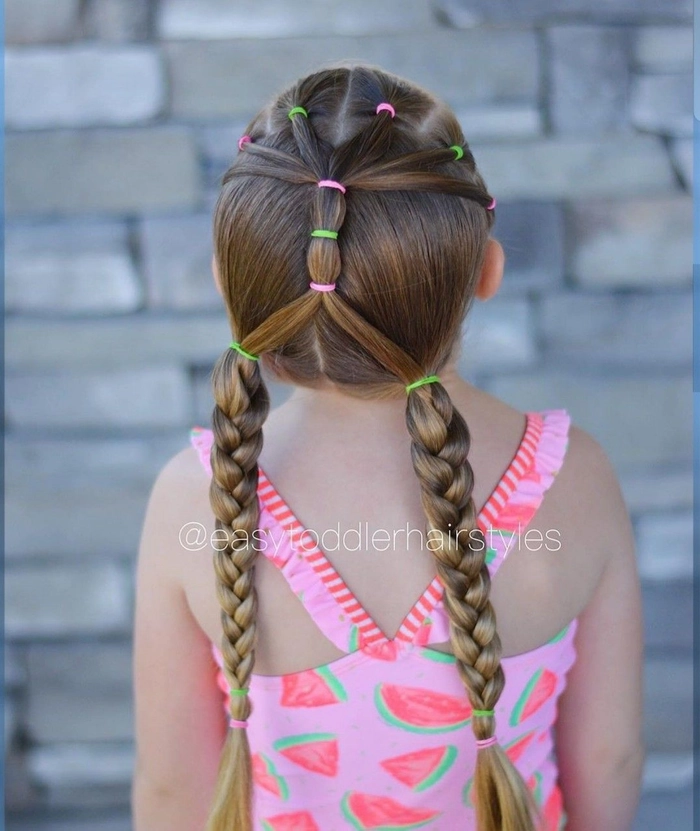 Toddler beach hair idea featuring a protective braided style with ocean-themed accessories Cute toddler with a braided updo and tiny seashell clips at the beach