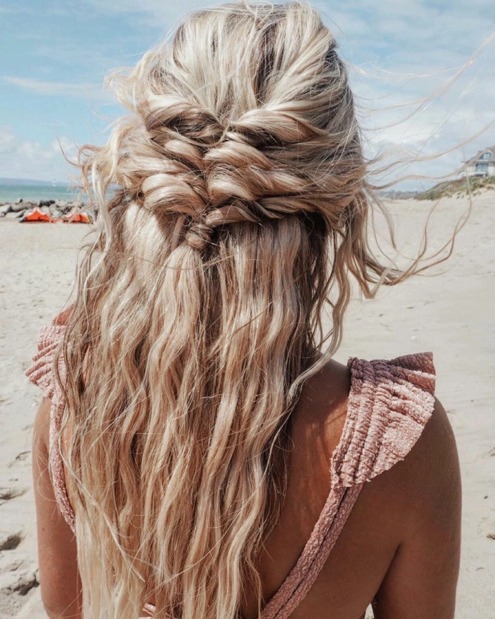 How to create a quick tropical vacation hair routine with braided waves and floral accents Woman with a messy braided updo and tropical flowers for a beach vacation hairstyle