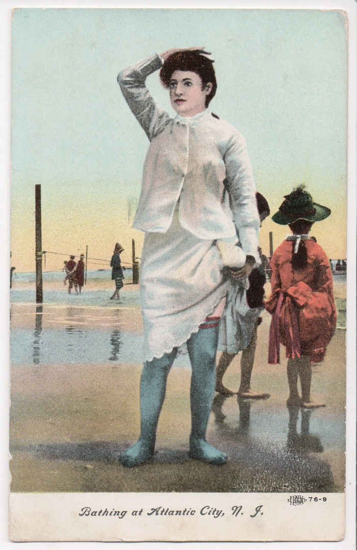 Woman with vintage pinup beach hairstyle, red lipstick, and retro swimwear smiling at the camera