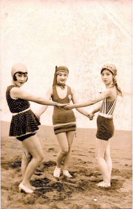 Woman with retro pinup curls and a bandana smiling at the sunny beach