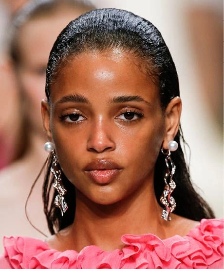 Woman showcasing wet look beach hair with glossy, sleek waves