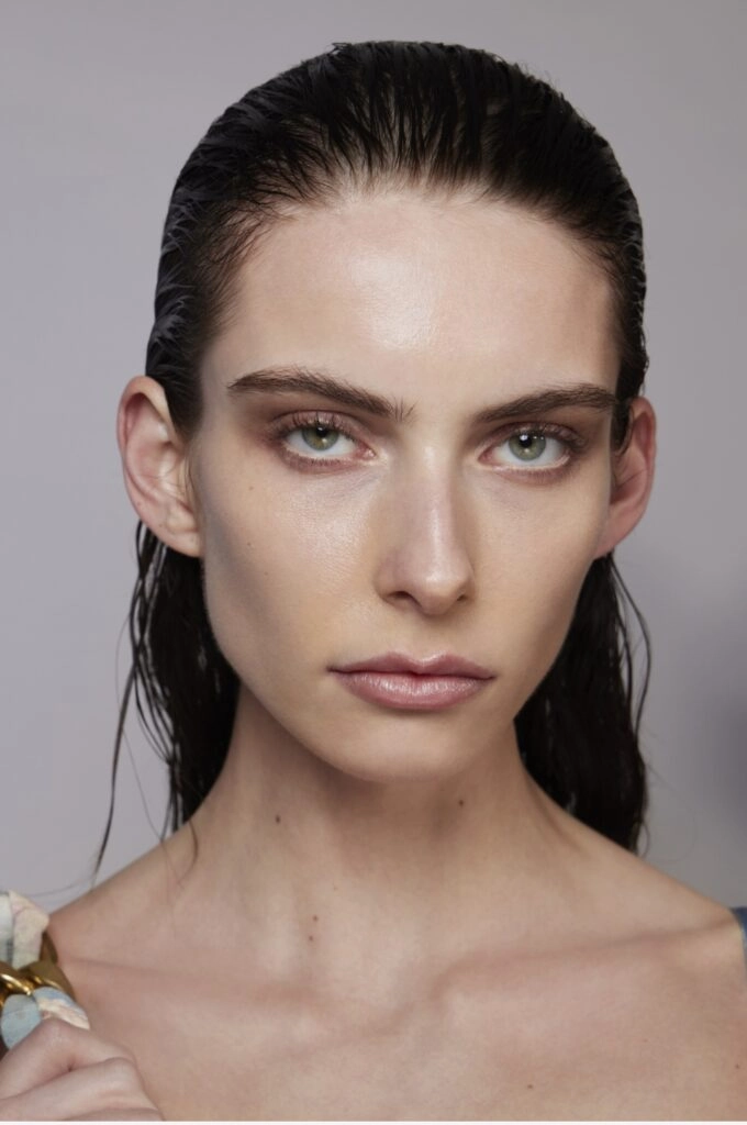 Wet look beach hair with glossy, defined waves for a sleek seaside style