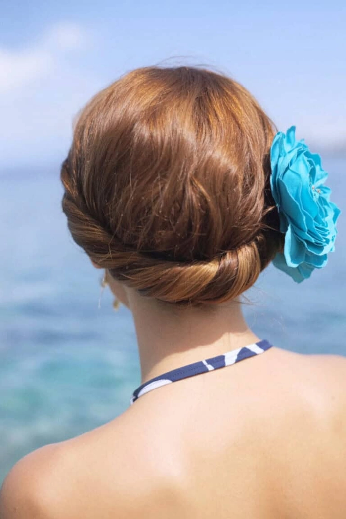 Woman with a windproof beach hairstyle smiling on the sandy shore