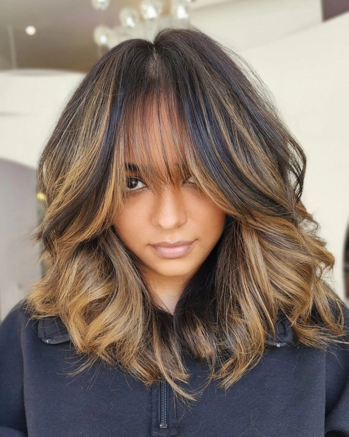 Relaxed bouncy blowout hairstyle on medium length hair perfect for a casual weekend look