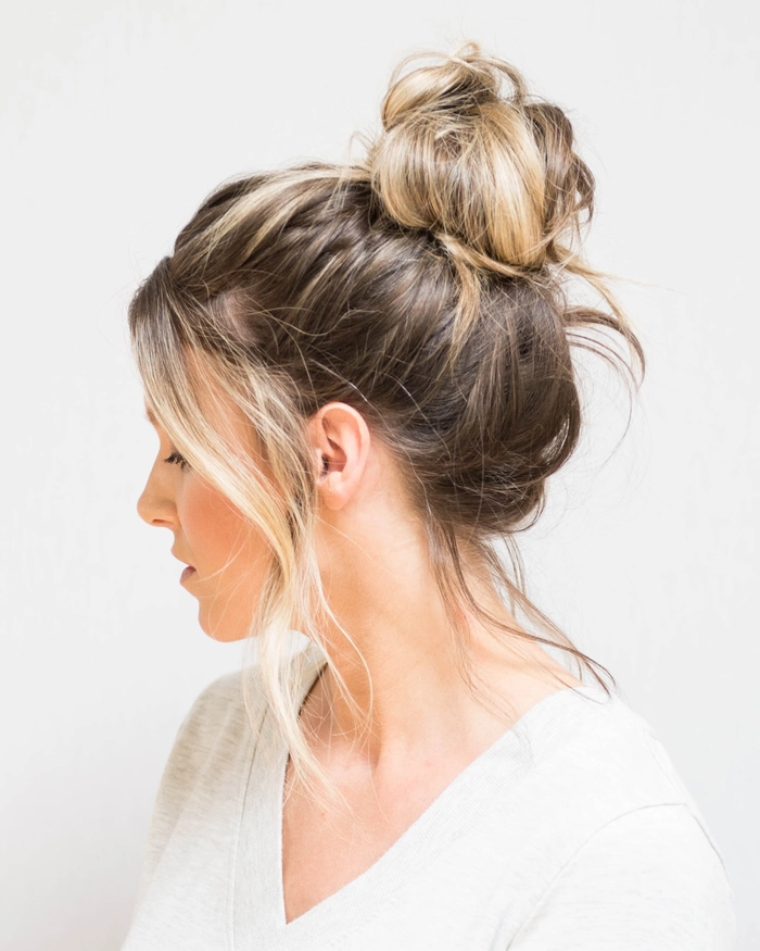 Casual messy bun style on long hair with loose strands and a relaxed vibe