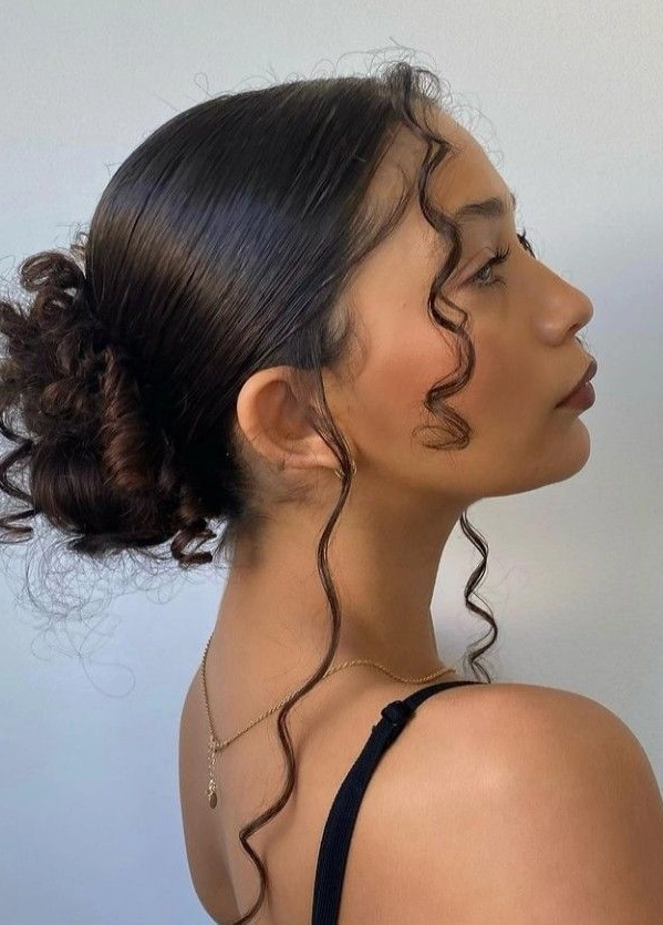 Curly hair styled in a sleek, low slicked back bun with gentle hold