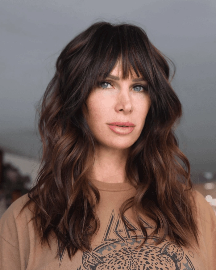 Effortless layered curtain bangs paired with casual loose waves for a soft, everyday hairstyle