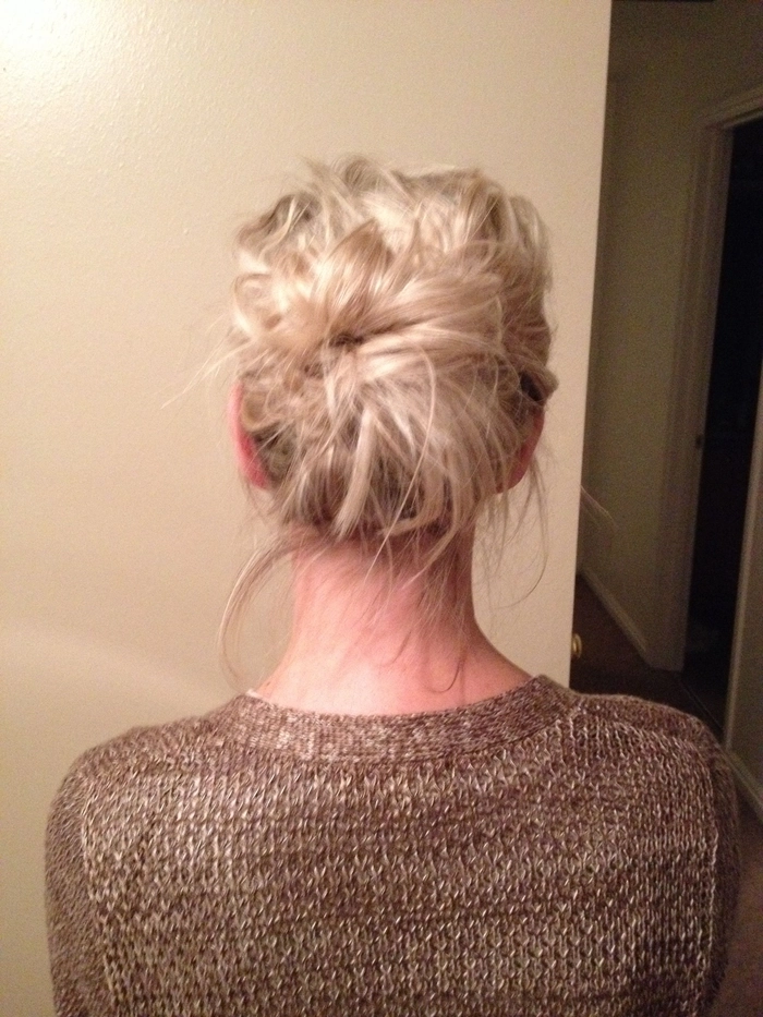 Casual everyday messy top knot for effortless second day styling Woman with an everyday messy top knot hairstyle perfect for second day hair