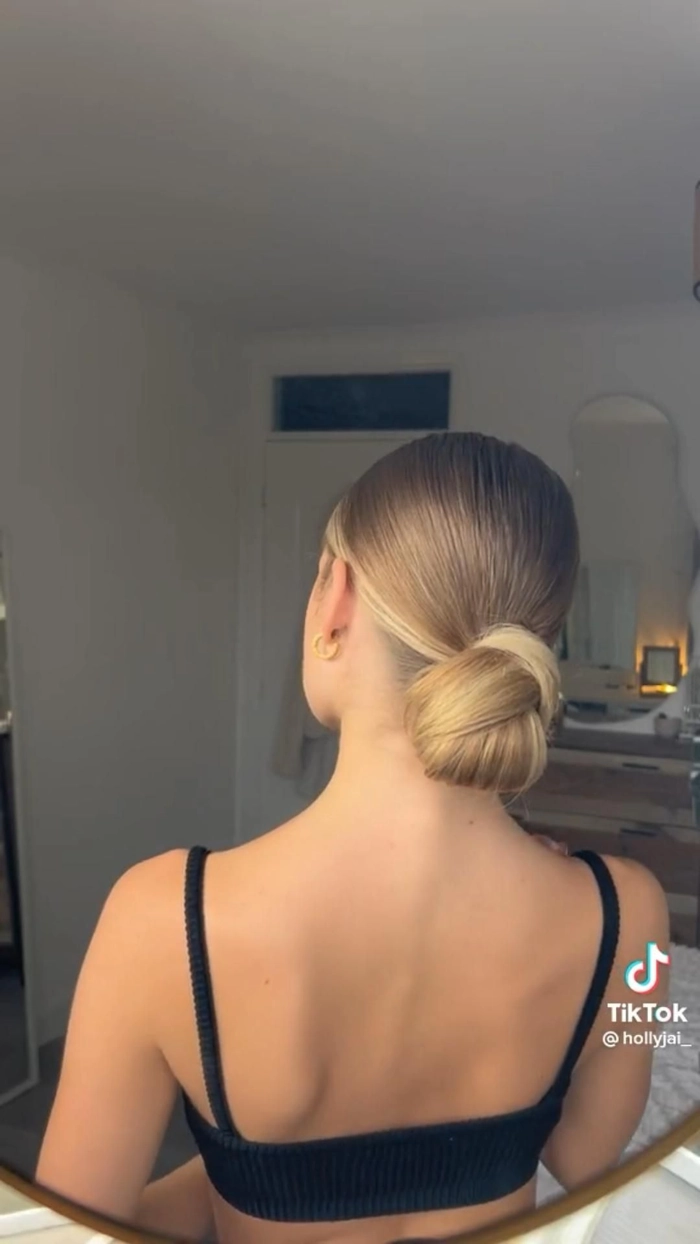 Woman with a quick slicked back low bun for a clean girl casual aesthetic hairstyle