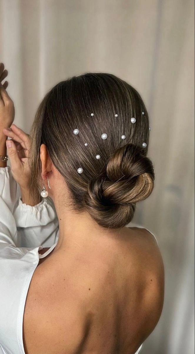 Pearl hair pin casual updo style for holiday parties A simple pearl hair pin updo for casual holiday gatherings shows a relaxed bun adorned with pearl pins