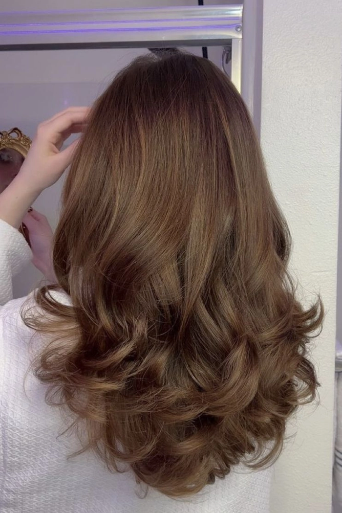 Relaxed bouncy blowout hairstyle on medium-length hair perfect for a casual weekend look