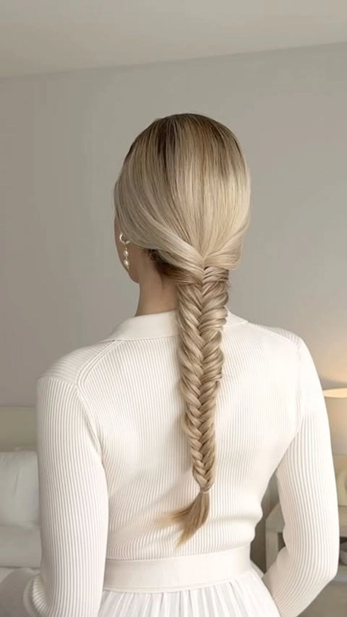 Relaxed fishtail braid hairstyle on thick wavy hair in a casual setting