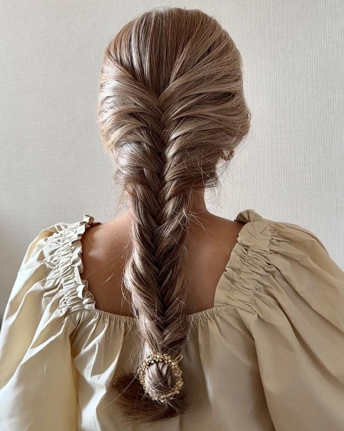 Relaxed fishtail braid hairstyle on thick wavy hair for a casual look