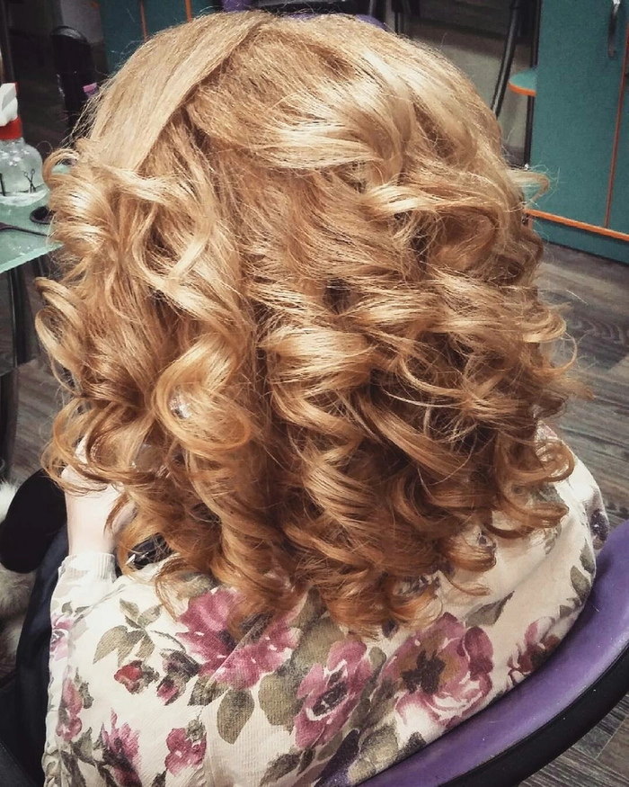 Casual hairstyle featuring soft, relaxed loose curls on medium hair length Relaxed loose curls styled on medium length hair for a casual look