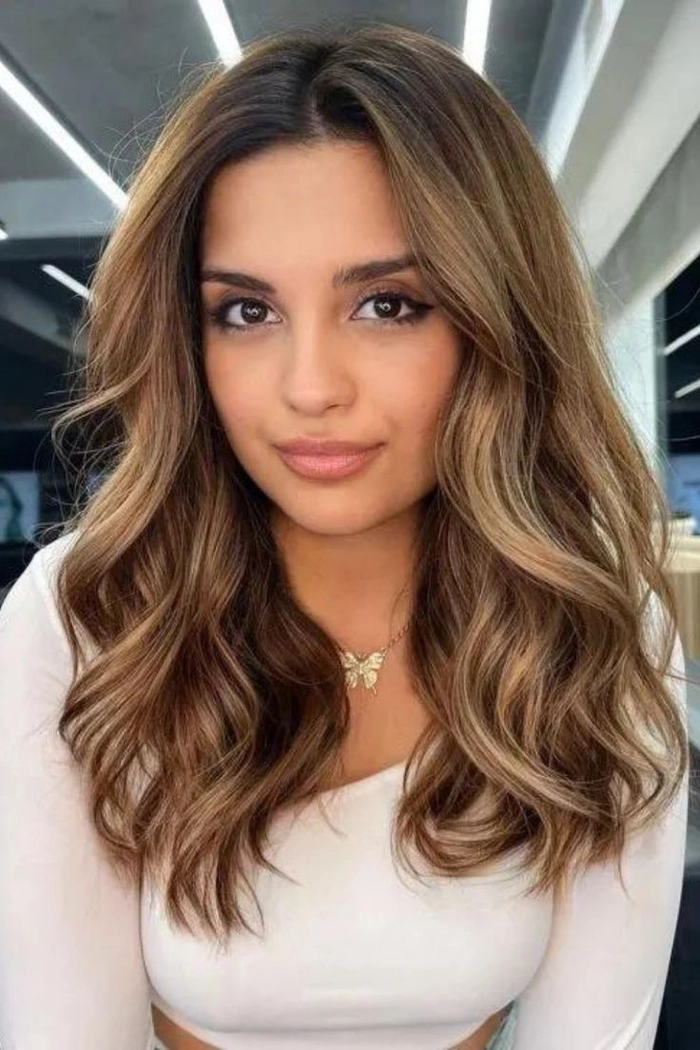 Casual hairstyle featuring relaxed loose curls on medium length hair Relaxed loose curls flowing on medium length hair for a casual look
