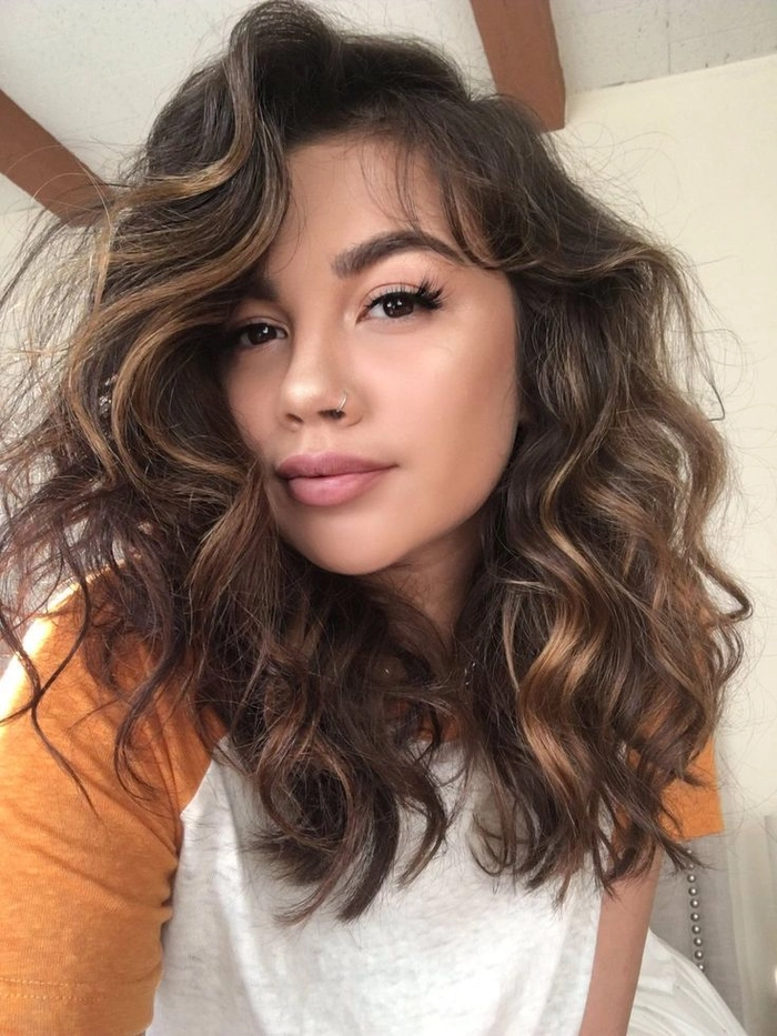 Casual hairstyle featuring soft relaxed curls on medium length hair Relaxed loose curls styled on medium length hair for a casual look