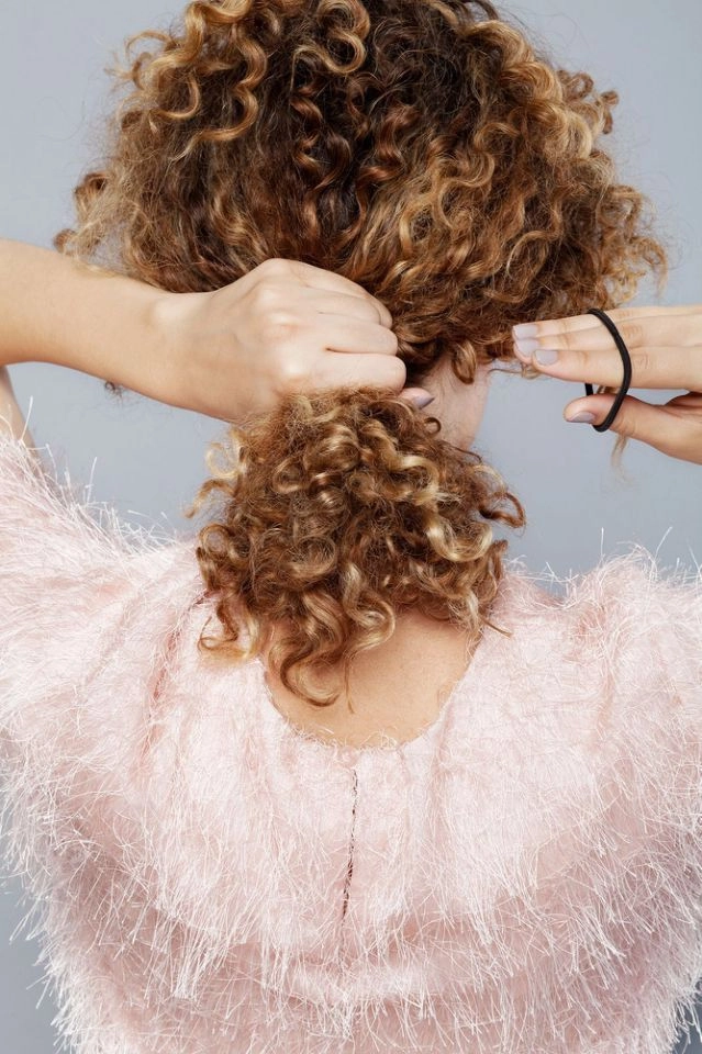Relaxed pinned up hairstyle on medium curly hair perfect for casual looks