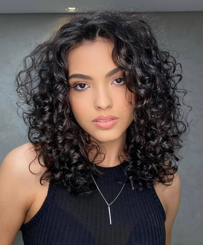 Relaxed pinned up style showcasing medium curly hair with effortless volume