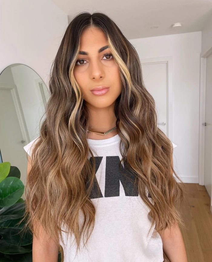 Relaxed tousled waves on long highlighted hair styled casually