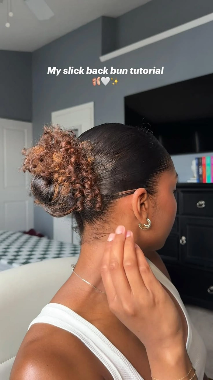 Side view of a curly slicked back bun with soft edges and a secure hold