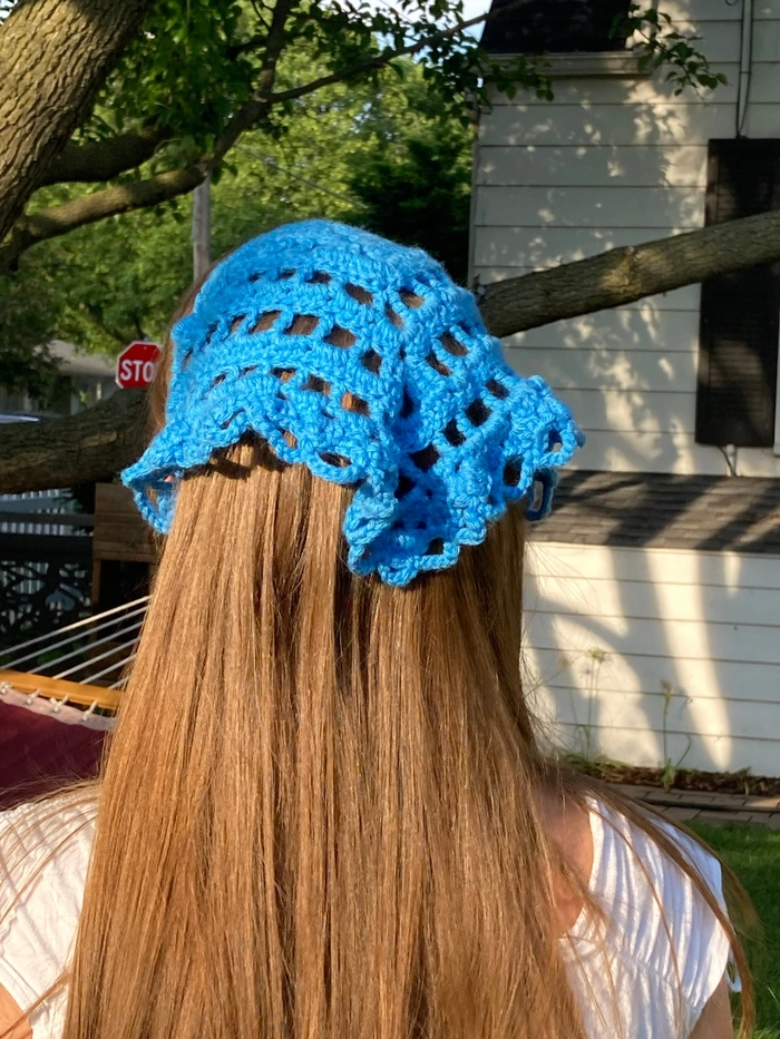 Easy bandana top knot hairstyle for summer festival season A woman showcasing a simple bandana top knot hairstyle at a casual summer festival