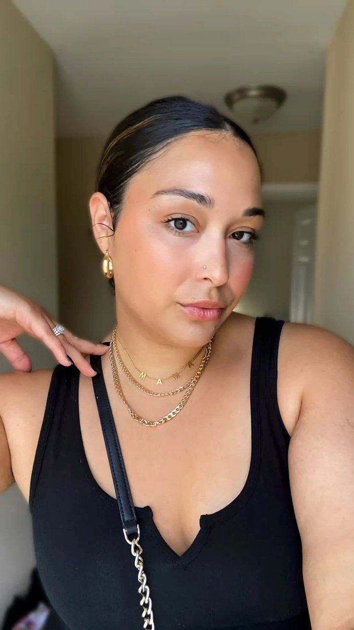 Woman with quick slicked back low bun achieving clean girl casual aesthetic