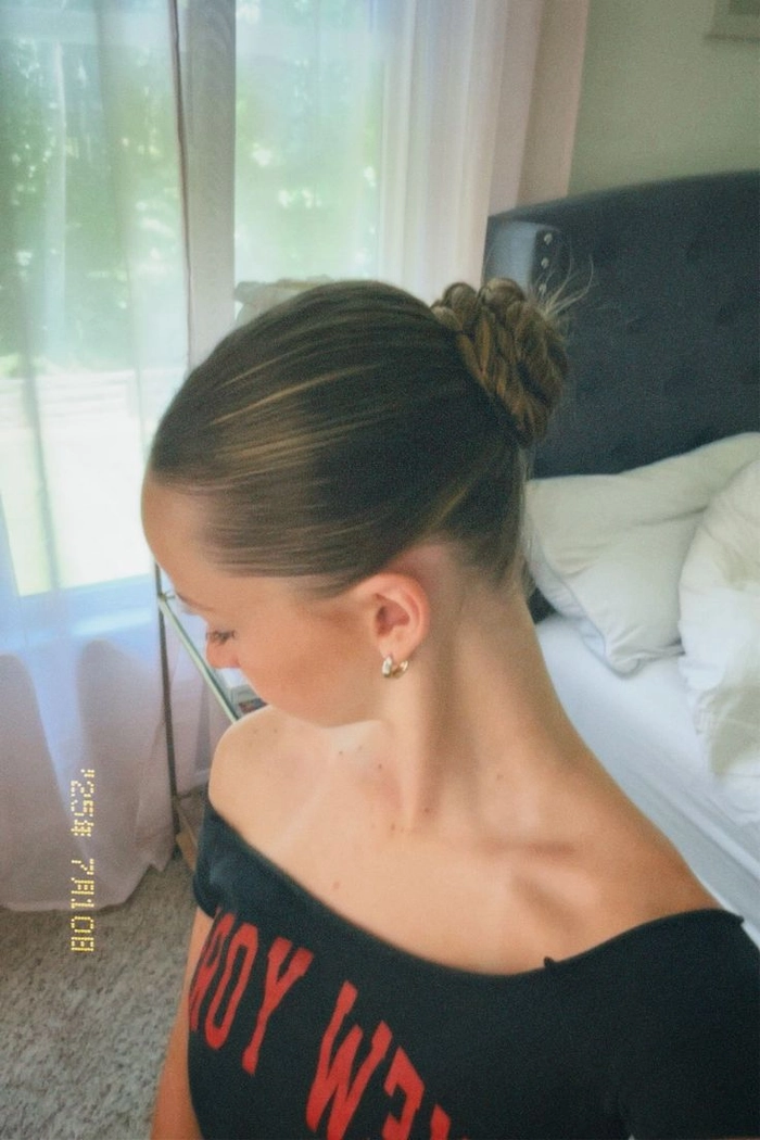 A woman with a quick slicked back low bun, embodying the clean girl casual aesthetic.