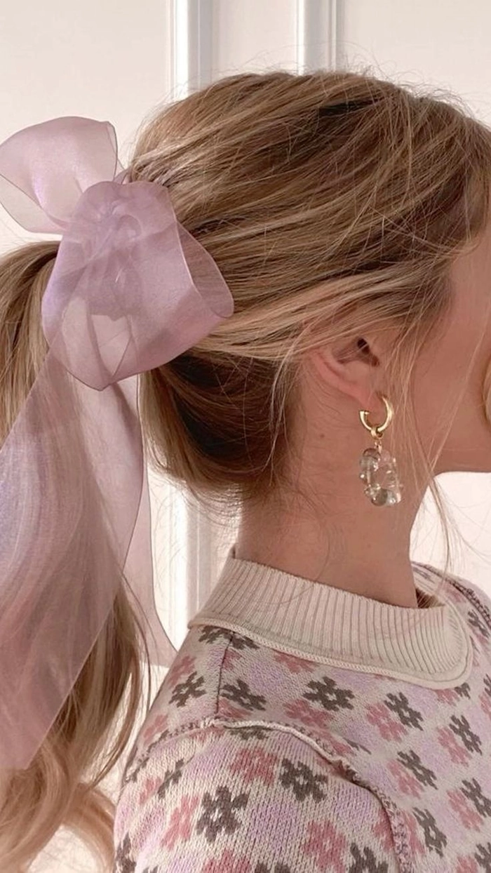 A woman in a sundress with a soft, quick coquette ribbon ponytail for a casual day out
