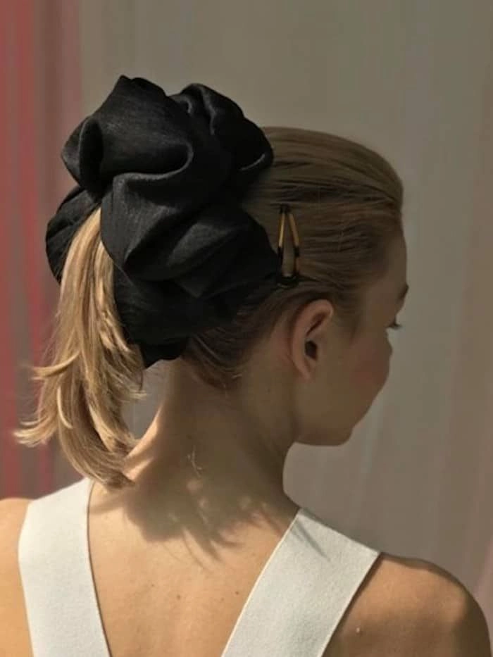 Woman with quick scrunchie hairstyle inspired by 90s casual aesthetics