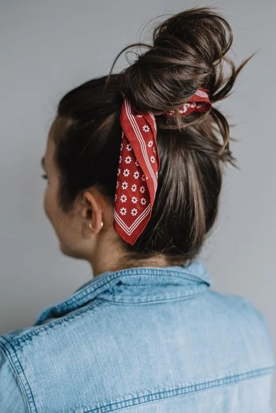 Simple bandana top knot hairstyle for a casual summer festival look Woman with a simple bandana top knot hairstyle, perfect for casual summer festivals