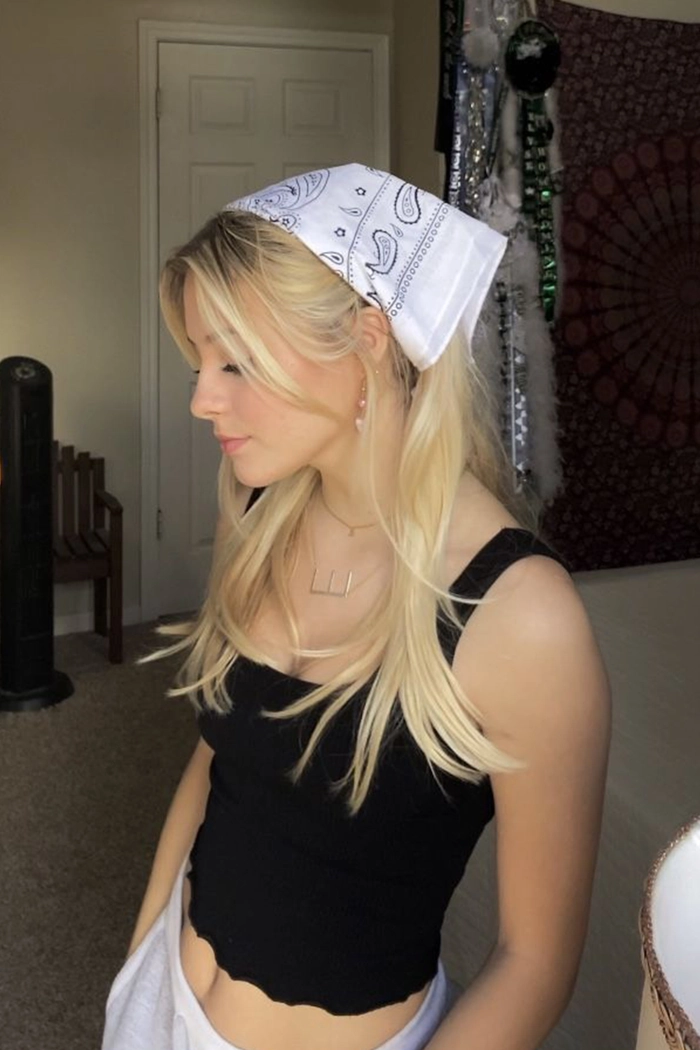Simple bandana top knot for casual summer festivals look Woman with a simple bandana top knot hairstyle at a summer festival