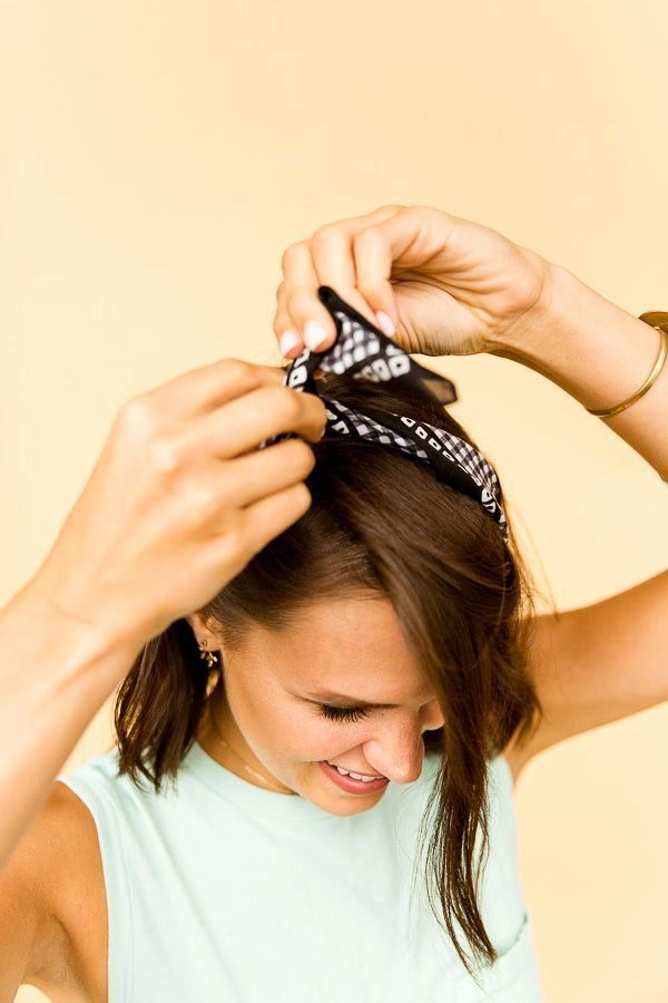 Easy bandana top knot perfect for outdoor festivals Woman with a simple bandana top knot hairstyle at a casual summer festival